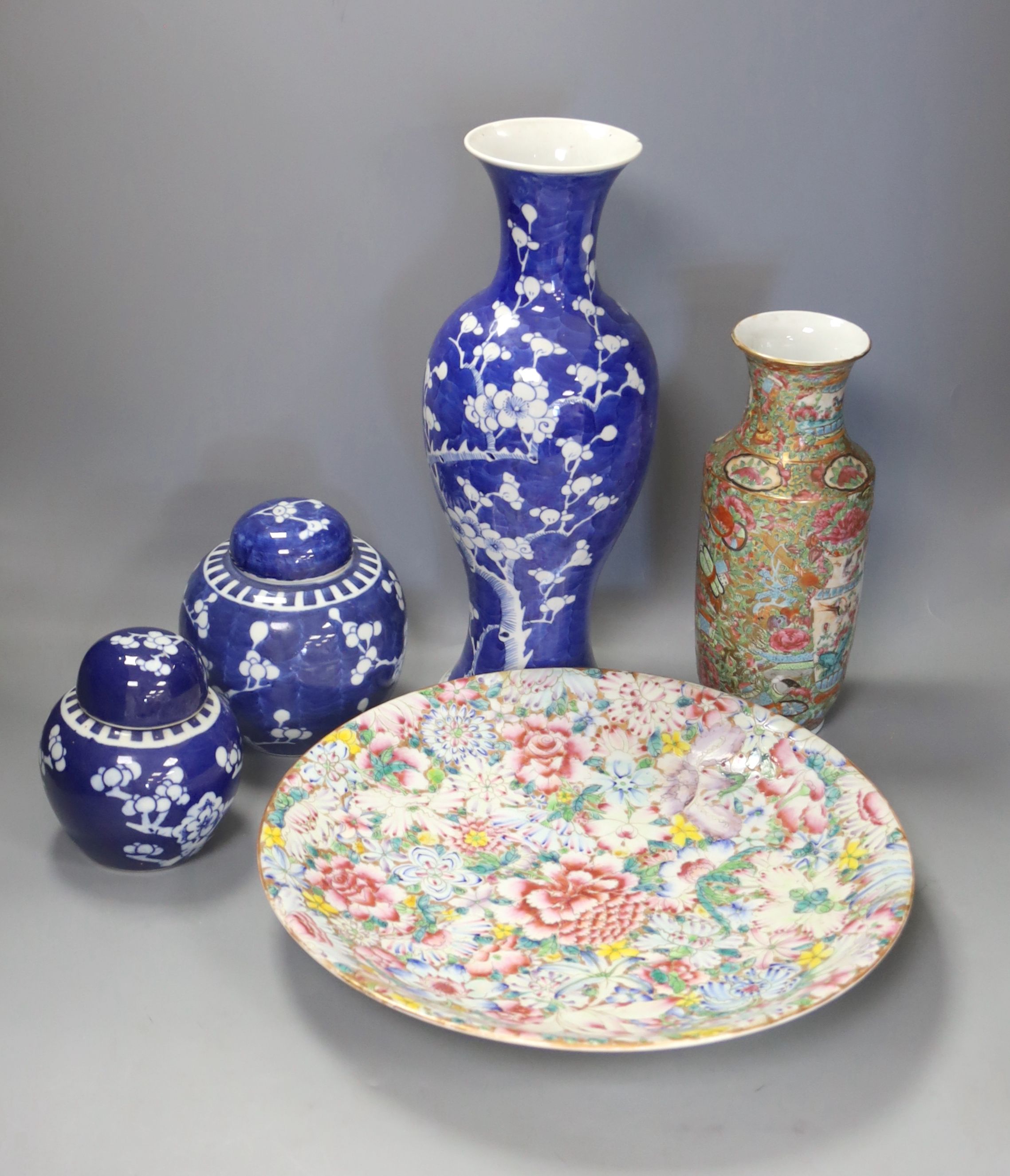 An early 20th century Chinese blue and white ‘prunus’ vase a Republic period millefleur dish, a similar Canton vase and two blue and white jars